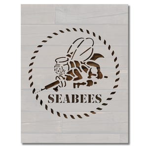 May include: A black and white stencil of a bee holding a wrench with the text "Seabees" in a circle.