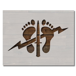 May include: Wooden sign featuring a design with two footprints, a dagger, and a lightning bolt. The design is cut out of the wood, revealing the natural grain. The background is a light gray, wooden plank design.