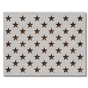 May include: A white wooden sign with a stencil of a US flag with stars cut out. The stars are arranged in a grid pattern.