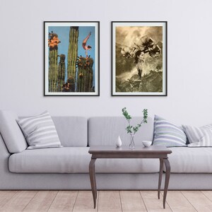 May include: Two framed art prints hanging on a white wall above a gray couch. The print on the left shows a woman doing a handstand on top of a tall cactus. The print on the right shows a woman with flowers on her head standing in a desert landscape.