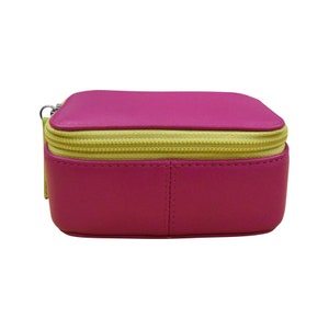Pode incluir: Uma pequena caixa de couro rosa com z&iacute;per amarelo. A caixa &eacute; ideal para guardar joias ou outros objetos pequenos.
