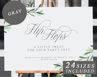 Pode incluir: Um sinal de casamento com fundo branco e folhagem verde. O sinal diz "Flip Flops" em uma fonte cursiva. O texto abaixo diz "Um pequeno mimo para seus pés de festa". O sinal também inclui os nomes do casal, a data do casamento e a hashtag. O texto "24 tamanhos incluídos" está em uma caixa branca com borda preta.