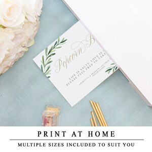 May include: Printable wedding favour sign with green watercolour leaves and gold calligraphy text that reads "Popcorn Bar. Life is salty, love is sweet. Please feel free to take."  The sign also includes the couple's names and wedding date.