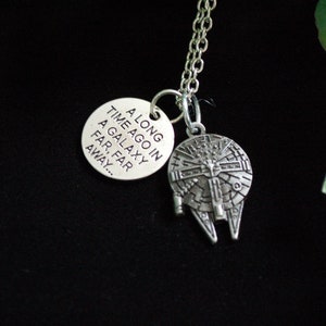 May include: A silver necklace with a charm that says "A long time ago in a galaxy far, far away..." and a charm shaped like the Millennium Falcon.