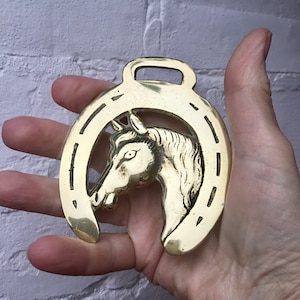 Horse brass horses head horseshoe traditional design. Nice patina. Handsome large piece of harness wear.