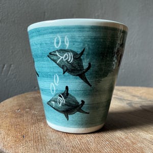 マン島工房の陶器で作られた、魚をモチーフにしたヴィンテージの小型プラントホルダー。水色/緑がかったグレーの釉薬。
