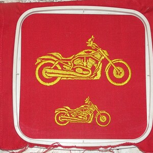 May include: A red fabric embroidery hoop with a gold embroidered image of a motorcycle. The motorcycle is shown twice, once large and once small.