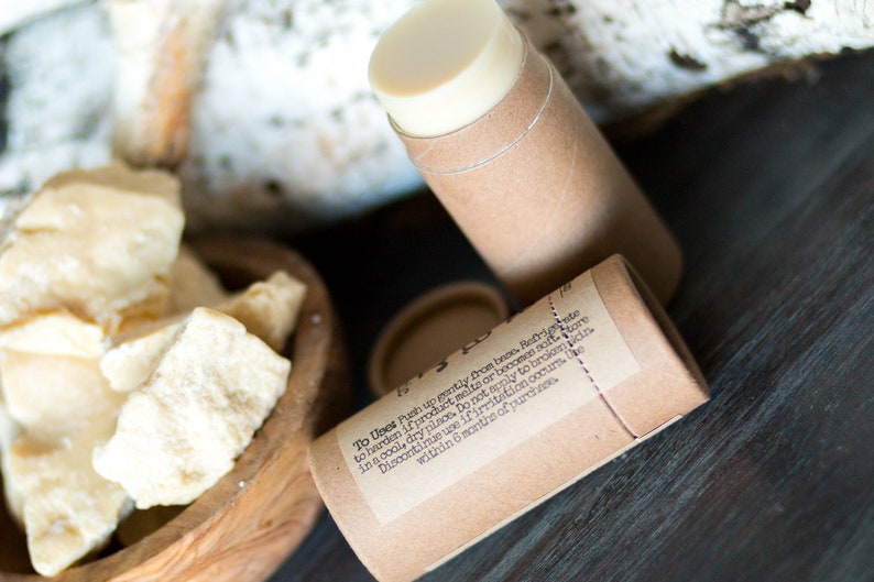 May include: A brown cardboard tube with a white label containing instructions for use. The label reads "To Uses Push up gently from base Refrate to harden if product melts or becomes soft store in a cool, dry place. Do not apply to broken skin. Discontinue use if irritation occurs. Use within 6 months of purchases".