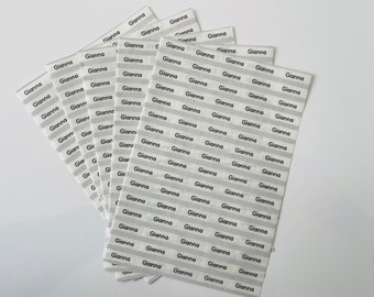 May include: A stack of white labels with the name "Gianna" printed in black on each label. The labels are arranged in rows and columns.