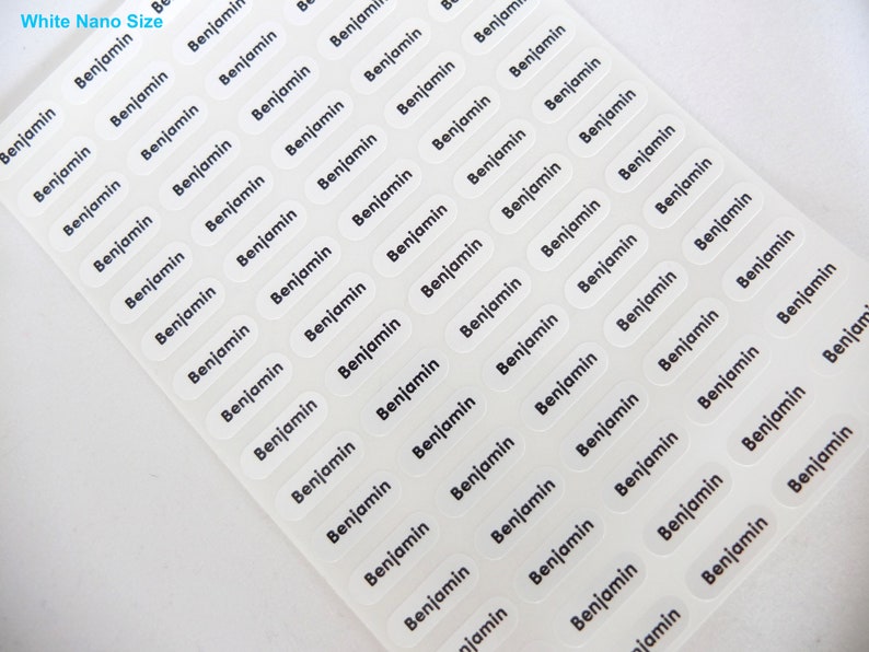 May include: A sheet of white, clear, oval-shaped labels with the name "Benjamin" printed in black on each label.