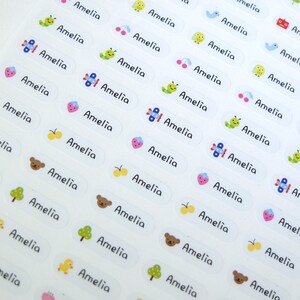 May include: A sheet of white labels with the name Amelia printed on each label. The labels have various colorful illustrations, including butterflies, airplanes, cherries, caterpillars, and bears.