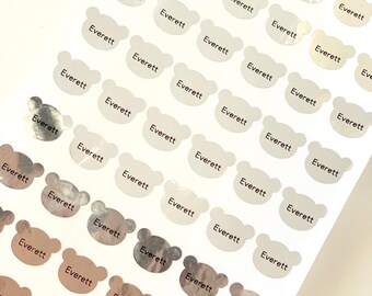 May include: A sheet of silver and brown bear-shaped stickers with the name "Everett" printed on each sticker.