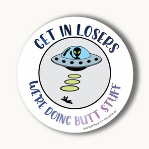 May include: A round sticker with a white background and a blue, gray, and green alien spaceship with the text "GET IN LOSERS WE'RE DOING BUTT STUFF" in a circle around the spaceship.