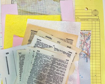 May include: A collection of vintage ephemera, including dictionary pages, maps, and colorful paper scraps. The assortment features yellow, pink, and cream-colored papers, with some pages showing handwritten text and printed words.