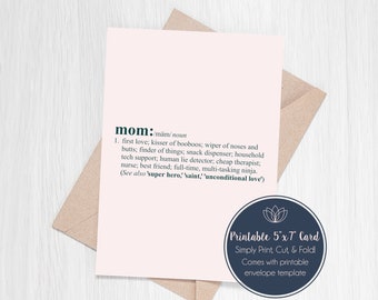 May include: A light pink card with the definition of "mom" in dark green text, including a list of attributes. The card is paired with a brown envelope. A circular sticker on the card reads "Printable 5"x7" Card".