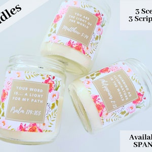 May include: Three glass candle jars with floral patterned labels and inspirational quotes. The labels are gold with white text. The quotes are "Your word is... a light for my path Psalm 119:105", "You are the light of the world Matthew 5:14", and "Shining as illuminators in the world Philippians 2:15".