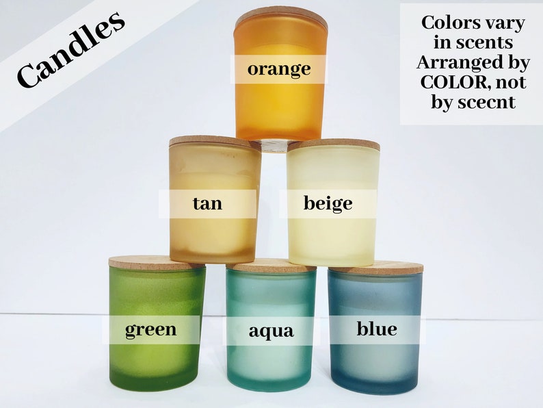 May include: Six candles in frosted glass jars with wooden lids. The candles are arranged in a pyramid shape, with the top candle being orange, the next row being tan and beige, and the bottom row being green, aqua, and blue. The text "Colors vary in scents Arranged by COLOR, not by scent" is written in black text on a white background.