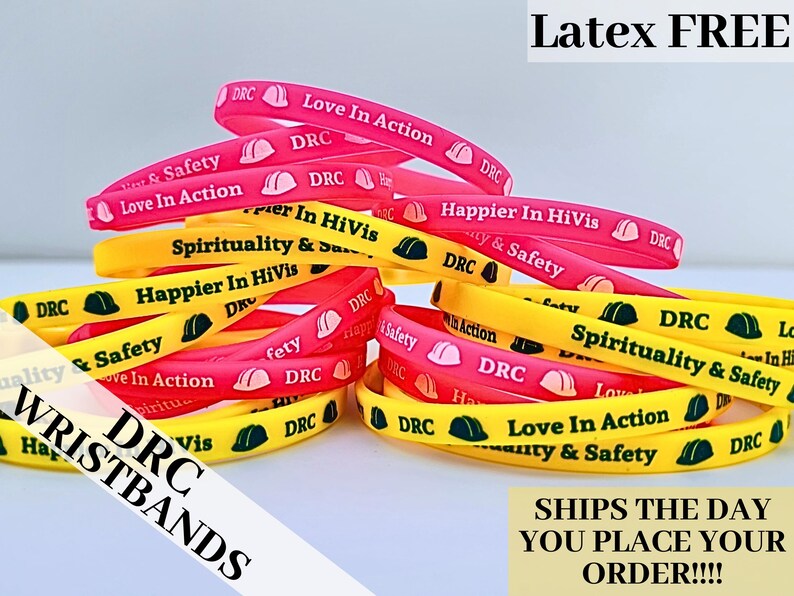 May include: A stack of colorful silicone wristbands with different messages, including "Love In Action", "Happier In HiVis", and "Spirituality & Safety". The wristbands are yellow, pink, and red with black lettering. The text "DRC Wristbands" is visible in the lower left corner of the image.