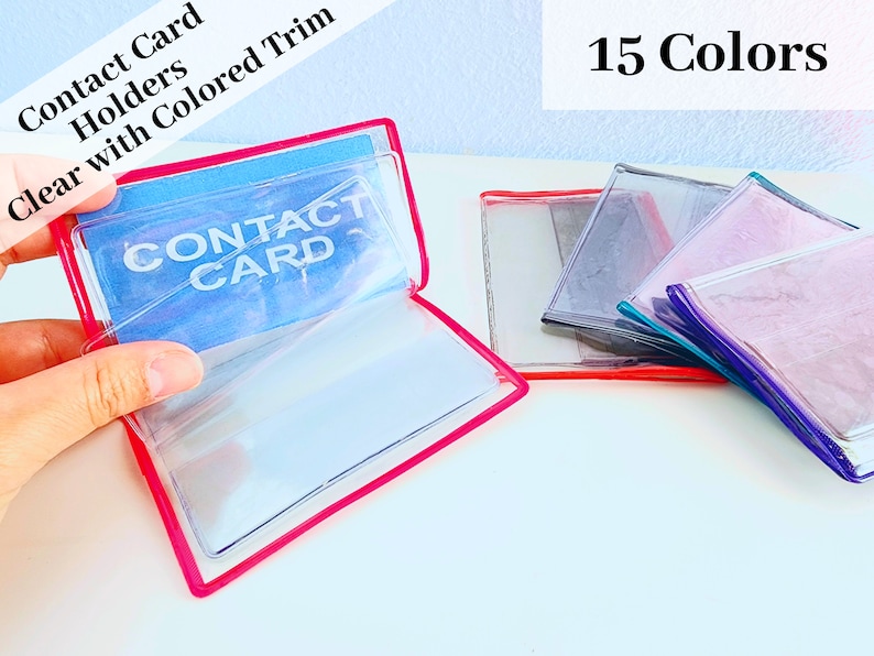May include: Clear plastic contact card holders with colored trim. The holders are open and show the words "Contact Card" printed on the inside. There are 15 different colors available.