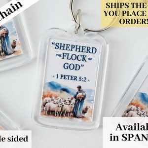Puede incluir: Llavero acrílico transparente con una imagen de acuarela de un pastor y ovejas, con el texto "SHEPHERD THE FLOCK OF GOD" y "- 1 PETER 5:2 -". El llavero es de doble cara y tiene un anillo plateado.