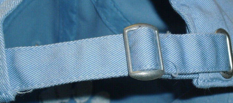 Pu&ograve; includere: Un berretto da baseball regolabile di colore azzurro chiaro con una chiusura a fibbia argentata.
