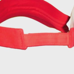 May include: A bright red visor, designed to shield the eyes from the sun. The visor features a curved brim and an adjustable strap. The material appears to be a lightweight fabric, suitable for outdoor activities. A white tag is attached.