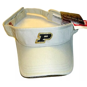 May include: A white visor with a black and gold embroidered "P" on the front. The visor has a black adjustable strap and a black and white label that says "American since 1914".