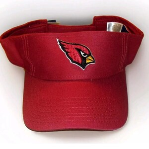 May include: A red visor with an embroidered cardinal logo. The logo is red, yellow, and black.