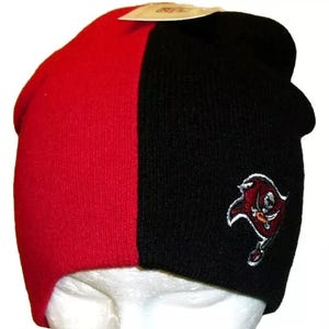 May include: A black and red knit beanie with a Tampa Bay Buccaneers logo embroidered on the side.