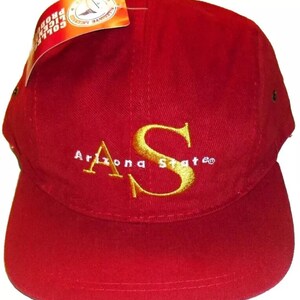 May include: Red baseball cap with a gold embroidered "Arizona State" logo. The cap has a white brim and a black adjustable strap.