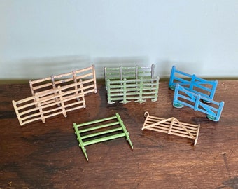 May include: A set of miniature wooden fences and gates, perfect for a model farm or train set. The fences are made of wood and painted in shades of green and brown. The gates are made of metal and painted blue.