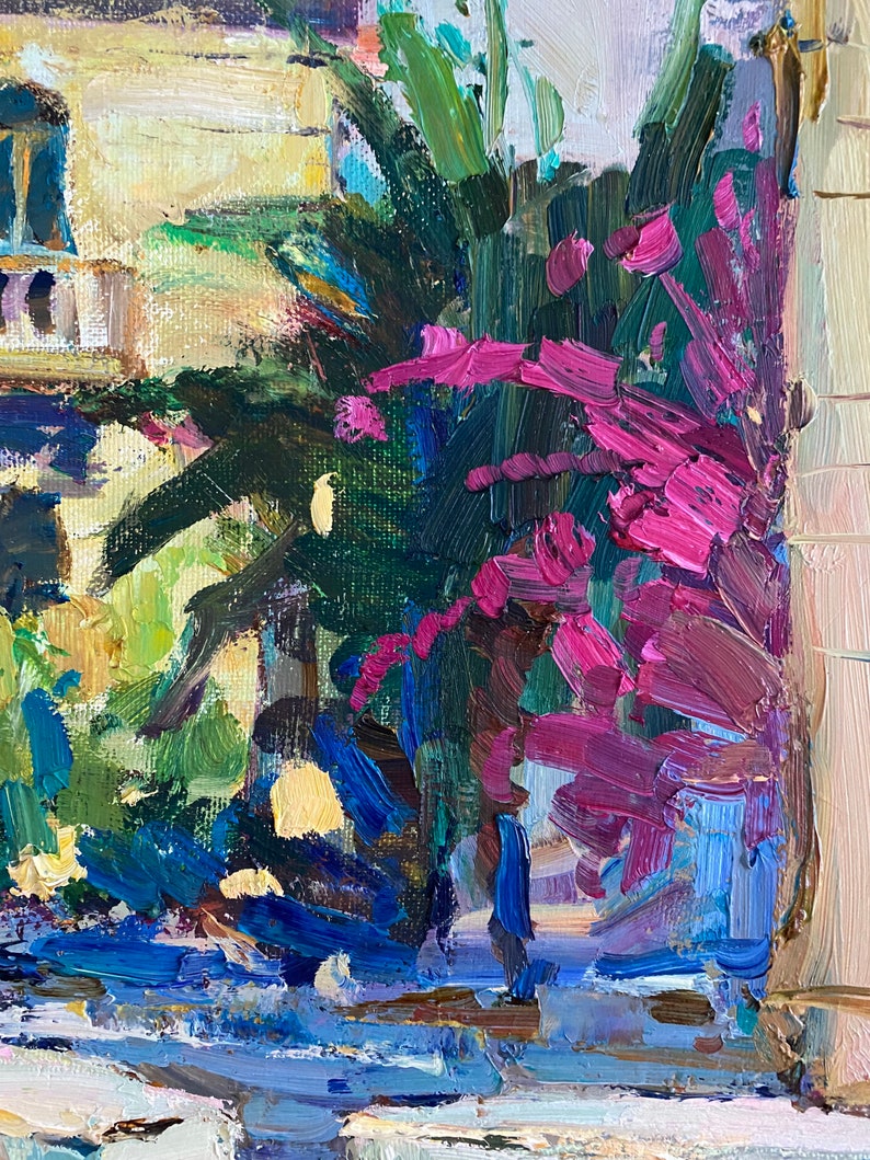 Puede incluir: Una pintura de un edificio con un exuberante arbusto verde y flores rosas en primer plano. El edificio est&aacute; pintado en tonos de amarillo y blanco, con acentos azules. El arbusto est&aacute; pintado en tonos de verde y marr&oacute;n, con flores rosas.