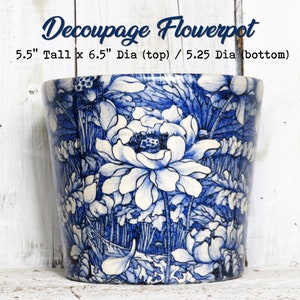 May include: A white ceramic flowerpot with a blue and white floral pattern. The pot is 5.5 inches tall, 6.5 inches in diameter at the top, and 5.25 inches in diameter at the bottom. The text "Decoupage Flowerpot" is written above the pot.