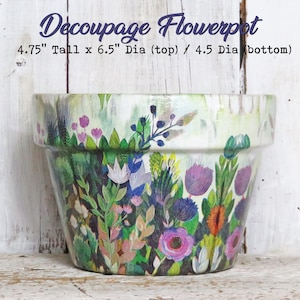 May include: A white ceramic flowerpot with a decoupage design of colorful flowers and greenery. The pot is 4.75 inches tall, 6.5 inches in diameter at the top, and 4.5 inches in diameter at the bottom.