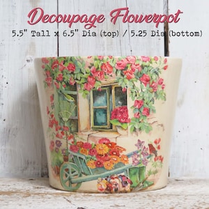 May include: Decoupage flowerpot, 5.5 inches tall, with a painted scene of a window, flowers, and a wheelbarrow. The top diameter is 6.5 inches, and the bottom diameter is 5.25 inches. The flowerpot features a cream-colored base with a floral design.