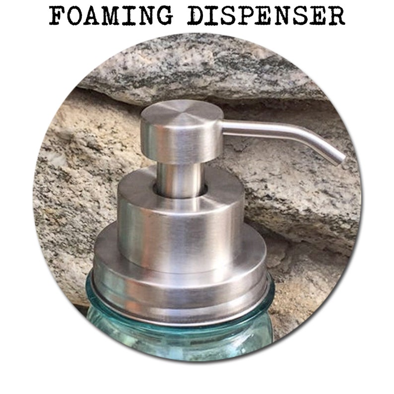 May include: Stainless steel foaming soap dispenser pump with a silver finish. The pump is attached to a clear glass jar with a blue tint.