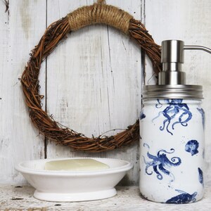 May include: White ceramic soap dispenser with a stainless steel pump and a blue and white octopus design. The dispenser is sitting on a white ceramic dish with a bar of soap.