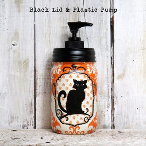 May include: Orange and white mason jar with a black lid and pump dispenser. The jar has a black cat silhouette with a white background and a decorative orange and white pattern.