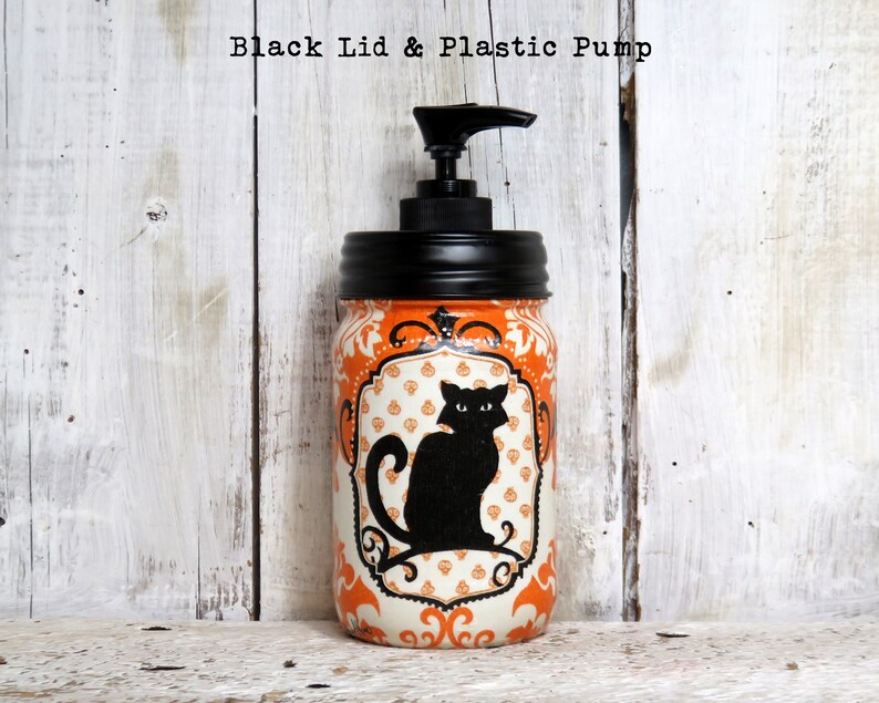 May include: Orange and white mason jar with a black lid and pump dispenser. The jar has a black cat silhouette with a white background and a decorative orange and white pattern.