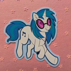 May include: A sticker featuring a cartoon pony with white fur, blue hair, and a blue tail. The pony wears purple sunglasses and headphones. A musical note is on its flank. The sticker is outlined in light blue, set against a pink background with star shapes.