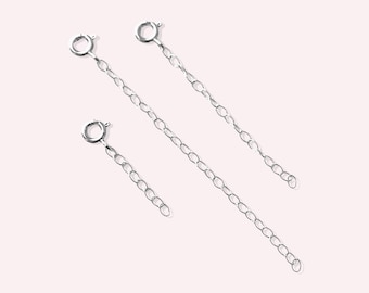 May include: Three silver chain extenders of different lengths. Each extender has a lobster clasp on one end and a jump ring on the other.