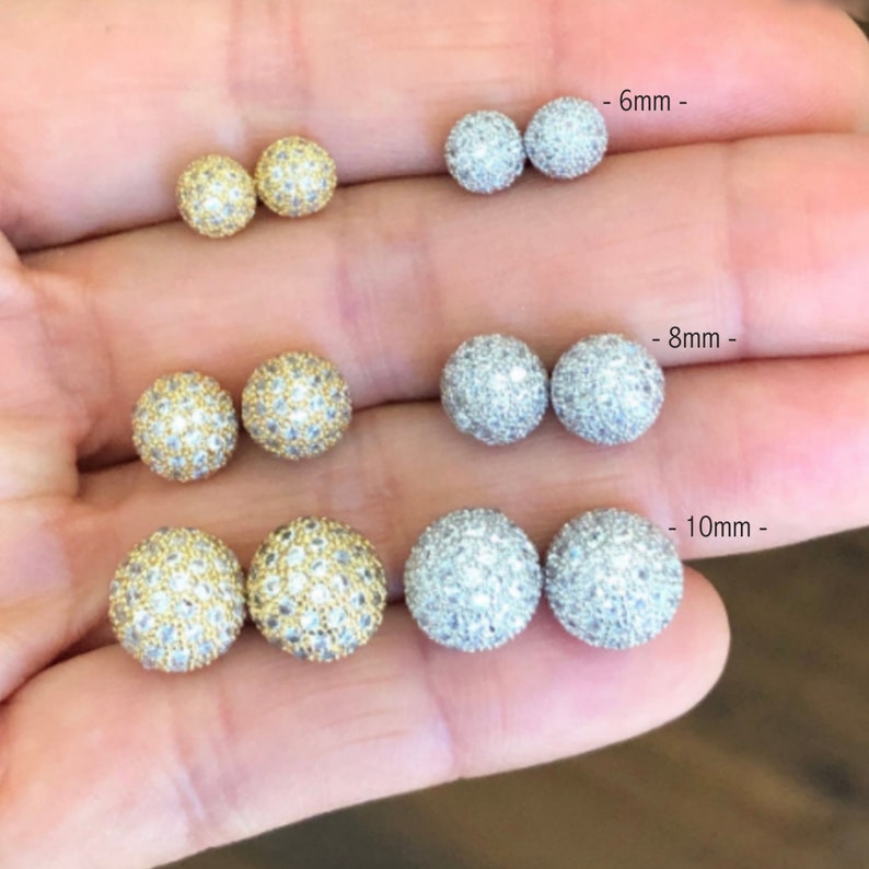 Three pairs of round, sparkly earrings in silver and gold. The earrings are shown in three sizes: 6mm, 8mm, and 10mm.