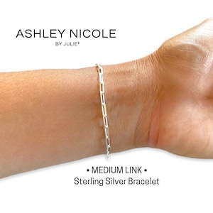May include: A silver chain bracelet with a medium link style. The bracelet is on a person's wrist. The text "MEDIUM LINK" and "Sterling Silver Bracelet" is below the image.