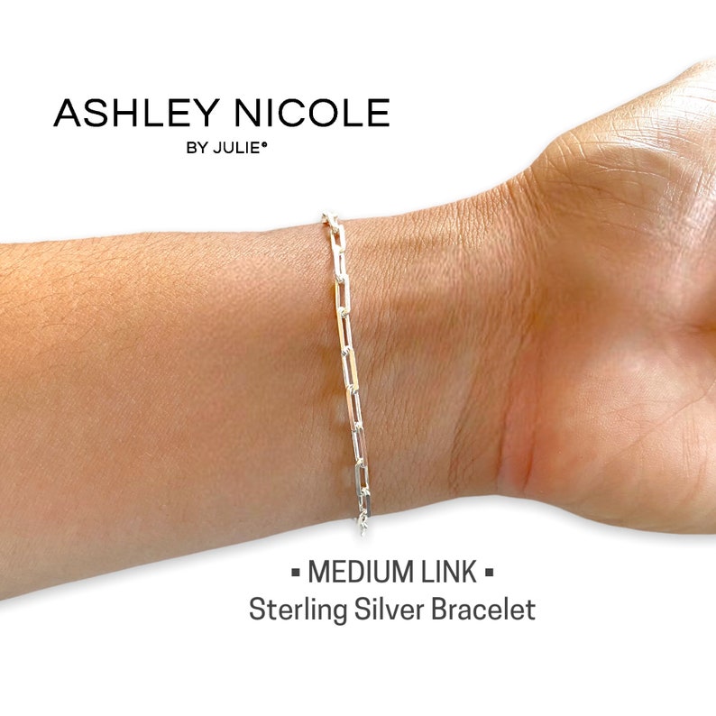 May include: A silver chain bracelet with a medium link style. The bracelet is on a person's wrist. The text "MEDIUM LINK" and "Sterling Silver Bracelet" is below the image.