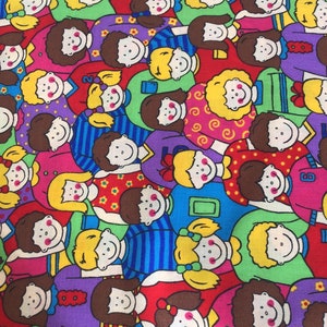 May include: A colorful fabric with a repeating pattern of smiling children wearing different colored clothing. The children are drawn in a simple cartoon style.