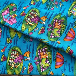 May include: Bright blue fabric with a whimsical pattern of frogs relaxing on lily pads. The frogs are wearing purple and orange clothing, and are surrounded by flowers, fish, and umbrellas. The fabric is perfect for quilting or other craft projects.