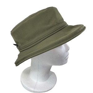 May include: A green, wide-brimmed hat with a buckle on the side. The hat is made of a water-resistant material and has a simple design.