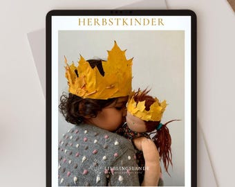 Op de afbeelding: Een digitaal dagboek voor herfstavontuur voor kinderen. De omslag toont een kind en een pop die kronen dragen gemaakt van herfstbladeren. De titel van het dagboek is "Herbstkinder" wat "Herfstkinderen" betekent.