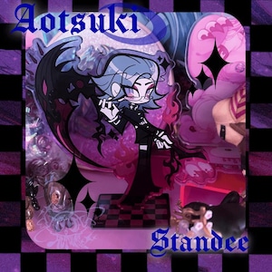 May include: A clear acrylic standee featuring a cartoon character with blue hair, glasses, and a black outfit. The standee has a black wing-like design and the text "Aotsuki" and "Standee". The base is a checkered pattern.