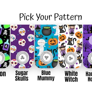 May include: A selection of Halloween-themed accessories with various patterns. Designs include ghosts, poison bottles, sugar skulls, a mummy, a witch, a haunted house, and bats. Each design features a silver button.